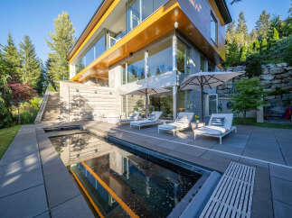 Experience luxury living in this modern architectural masterpiece, featuring expansive glass walls and natural wood accents.