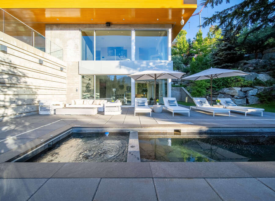 Experience luxury outdoor living with this stunning patio featuring a modern pool and spa.