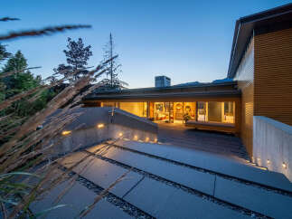 Experience modern luxury in this stunning home, featuring a sleek concrete and wood exterior.