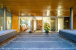 Step into modern luxury with this stunning entryway featuring sleek wooden ceilings and a vibrant orange accent wall.