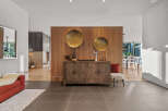 This entryway features a stunning wooden accent wall adorned with large brass circular art pieces.