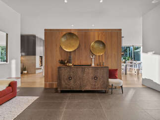 This entryway features a stunning wooden accent wall adorned with large brass circular art pieces.