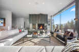 Experience luxury mountain living in this stunning contemporary home, featuring a grand fireplace as the centerpiece of the living room.