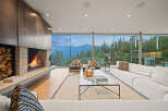 Experience luxury living in this stunning modern living room, featuring a dramatic concrete fireplace with a stacked wood accent and a sleek metal surround.