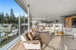 Experience modern luxury in this stunning open-concept living space, featuring floor-to-ceiling windows that bathe the room in natural light and offer breathtaking views of the surrounding forest.