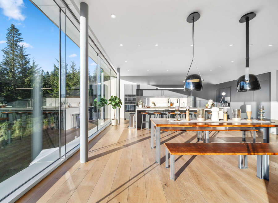 Experience modern living in this stunning home featuring expansive floor-to-ceiling windows that flood the space with natural light and offer breathtaking views of the surrounding forest.