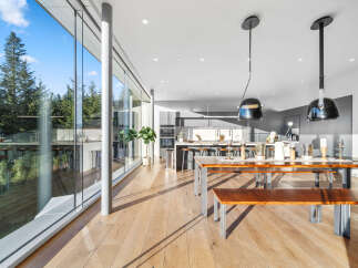 Experience modern living in this stunning home featuring expansive floor-to-ceiling windows that flood the space with natural light and offer breathtaking views of the surrounding forest.