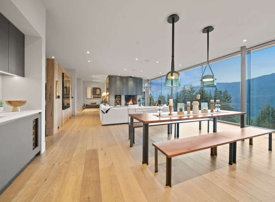 Experience luxury living with this stunning open-concept space featuring a modern fireplace and expansive floor-to-ceiling windows offering breathtaking mountain views.