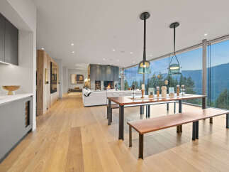 Experience luxury living with this stunning open-concept space featuring a modern fireplace and expansive floor-to-ceiling windows offering breathtaking mountain views.