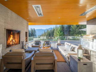 Experience luxurious outdoor living with this stunning patio featuring a cozy fireplace and a fully equipped grill station.