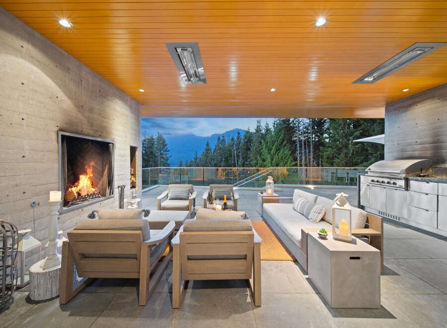 Experience luxurious outdoor living with this stunning covered patio, featuring a modern fireplace and a fully equipped outdoor kitchen.