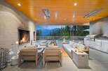Experience luxurious outdoor living with this stunning covered patio, featuring a modern fireplace and a fully equipped outdoor kitchen.
