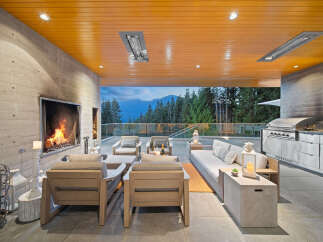 Experience luxurious outdoor living with this stunning covered patio, featuring a modern fireplace and a fully equipped outdoor kitchen.