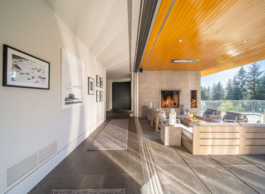Experience seamless indoor-outdoor living with this stunning covered patio, featuring a modern concrete fireplace and comfortable lounge seating.