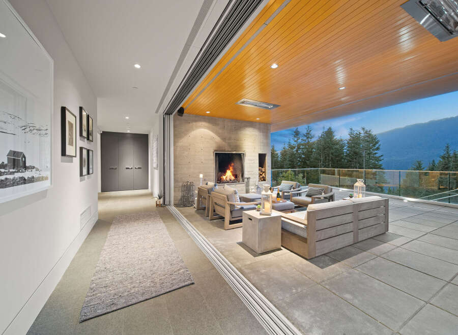 Experience seamless indoor-outdoor living with this stunning covered patio, featuring a cozy fireplace and comfortable seating.