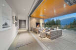 Experience seamless indoor-outdoor living with this stunning covered patio, featuring a cozy fireplace and comfortable seating.