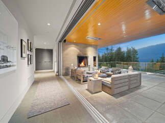 Experience seamless indoor-outdoor living with this stunning covered patio, featuring a cozy fireplace and comfortable seating.