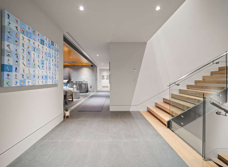 Experience modern luxury in this stunning home featuring a sleek staircase with glass railings and warm wood treads.