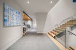 Experience modern luxury in this stunning home featuring a sleek staircase with glass railings and warm wood treads.