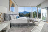 Experience breathtaking mountain views from this luxurious master bedroom, featuring expansive floor-to-ceiling windows that flood the space with natural light.