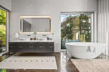 Experience modern luxury in this stunning bathroom featuring a freestanding soaking tub with a sleek chrome faucet and a spacious double vanity with vessel sinks.