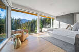 Experience breathtaking mountain views from this luxurious bedroom, featuring expansive floor-to-ceiling windows that flood the space with natural light.