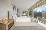 Experience luxury living in this stunning bedroom featuring a king-sized bed with plush linens and a cozy throw blanket.