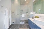 Experience modern luxury in this stunning bathroom featuring a spacious glass-enclosed shower with a rainfall showerhead.