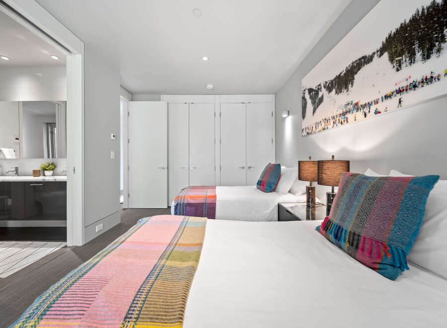 Experience comfort and style in this inviting bedroom featuring two plush beds, perfect for families or groups.