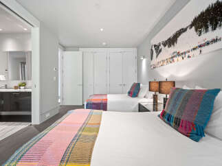 Experience comfort and style in this inviting bedroom featuring two plush beds, perfect for families or groups.