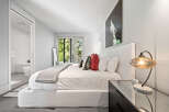 Experience modern luxury in this serene bedroom featuring a plush king-sized bed adorned with decorative pillows and a cozy throw.