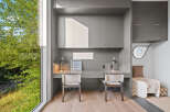 This modern home office features a sleek grey built-in desk with two matching chairs, perfect for a shared workspace or a couple.