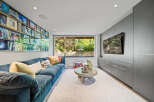 Experience ultimate relaxation in this modern living room, featuring a plush blue sectional sofa perfect for movie nights.
