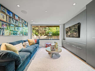 Experience ultimate relaxation in this modern living room, featuring a plush blue sectional sofa perfect for movie nights.