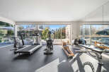 This modern home gym boasts a full suite of cardio equipment, including treadmills and an elliptical, perfect for your fitness routine.