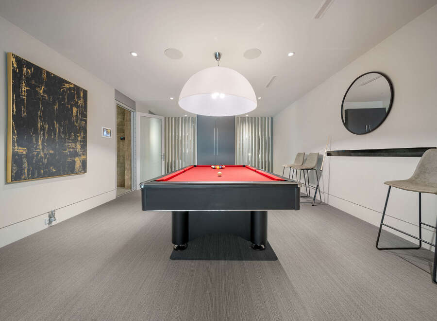 Experience ultimate entertainment in this stylish game room, featuring a vibrant red felt pool table perfect for friendly competitions.
