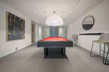 Experience ultimate entertainment in this stylish game room, featuring a vibrant red felt pool table perfect for friendly competitions.