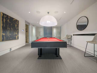 Experience ultimate entertainment in this stylish game room, featuring a vibrant red felt pool table perfect for friendly competitions.