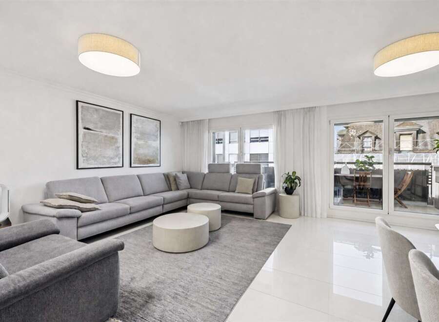 Experience modern living in this spacious living room, featuring a large sectional sofa perfect for gatherings.