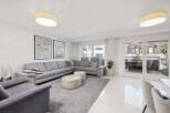 Experience modern living in this spacious living room, featuring a large sectional sofa perfect for gatherings.