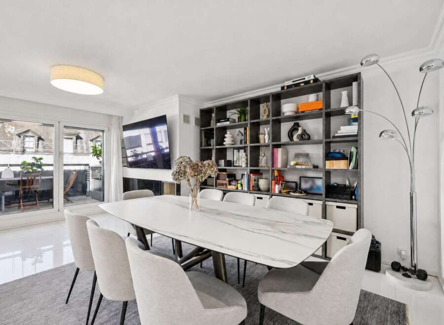 Experience modern living in this elegant dining area, featuring a stunning marble-top dining table surrounded by comfortable upholstered chairs.