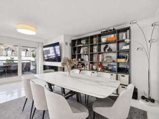 Experience modern living in this elegant dining area, featuring a stunning marble-top dining table surrounded by comfortable upholstered chairs.