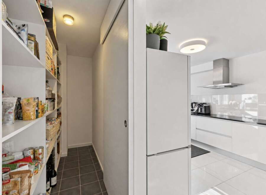 Discover a spacious pantry with ample shelving, perfect for organizing all your groceries and kitchen essentials.