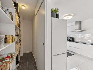 Discover a spacious pantry with ample shelving, perfect for organizing all your groceries and kitchen essentials.