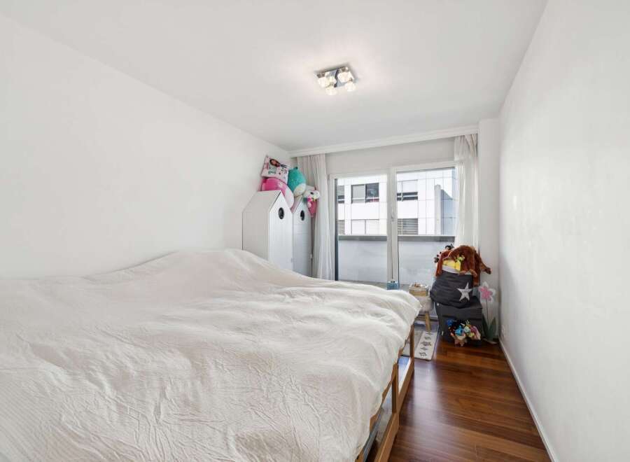 This charming bedroom features a comfortable bed with a white duvet, perfect for relaxation.
