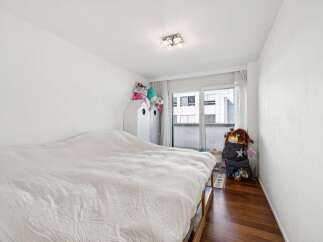This charming bedroom features a comfortable bed with a white duvet, perfect for relaxation.
