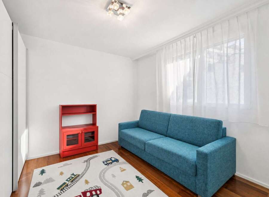 This inviting room features a comfortable blue sofa, perfect for relaxing or entertaining.