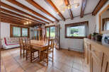 Experience cozy living in this charming dining area, featuring exposed wooden beams and a rustic wooden dining set perfect for family meals.