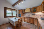 This charming kitchen features rustic wooden cabinetry and a cozy dining nook with a window overlooking the outdoors.