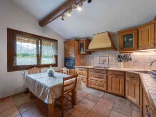 This charming kitchen features rustic wooden cabinetry and a cozy dining nook with a window overlooking the outdoors.